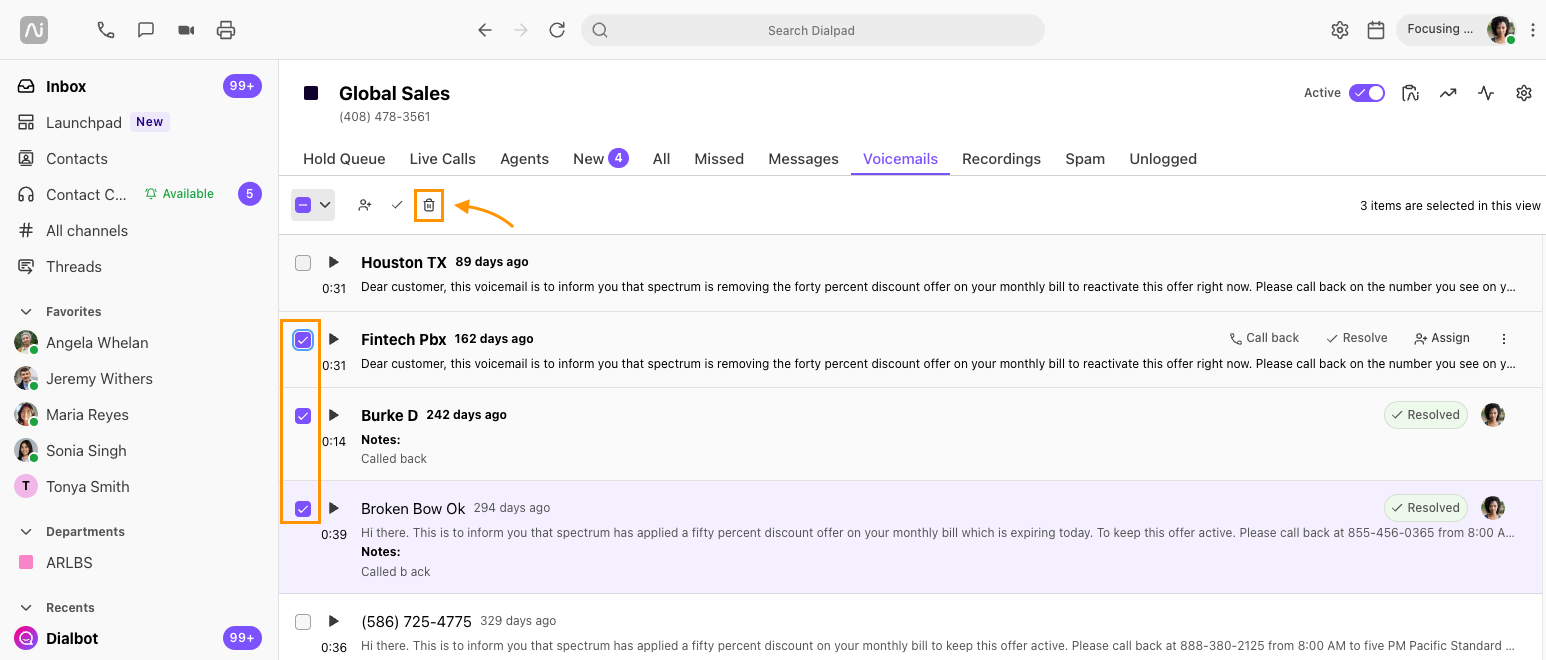 Screenshot of Dialpad open to the Voicemails tab, showing three selected voicemails with orange boxes highlighting the selection checkboxes on the left and an orange arrow pointing to the top bulk delete trash icon.