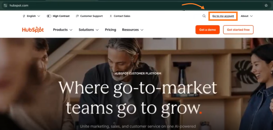 Screenshot of the HubSpot homepage featuring an orange arrow pointing to an orange box around the 'Go to my account' button in the upper right navigation header.