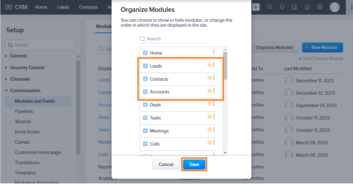 Screenshot of the Zoho CRM "Organize Modules" pop-up menu, with orange boxes highlighting the selected Leads, Contacts, and Accounts checkboxes as well as the blue Save button at the bottom.